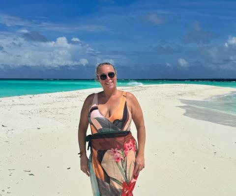 White woman smiling on sandy beach in the Maldives 