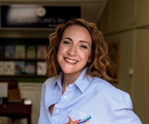 Smiling white woman with chin-length brown hair and blue striped shirt