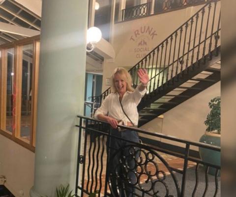 Woman with blonde hair smiling by balcony