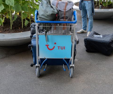An airport luggage trolley featuring the Tui logo