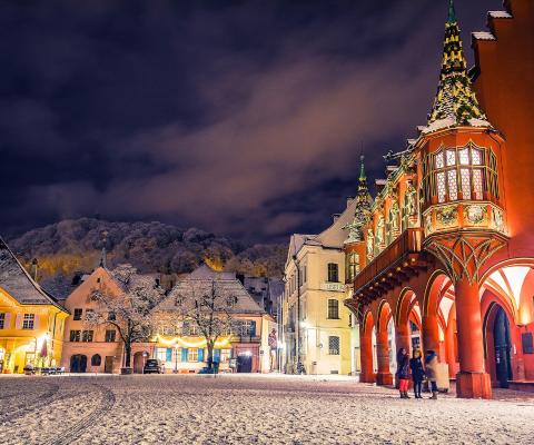 A European town square with cobbled ground and a church during a frosty night