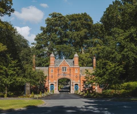 Wide shot of entrance to luxurious red brick hotel in England 