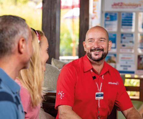 A member of Jet2 check-in staff assists passengers