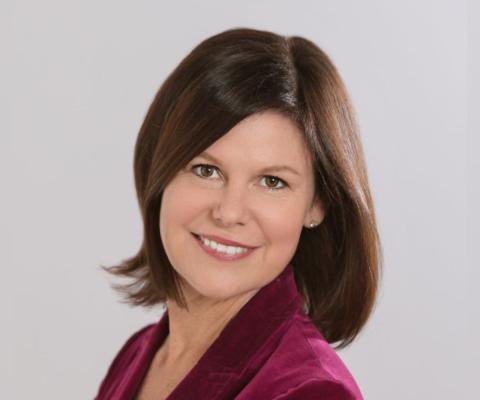 Professional headshot of smiling white woman with brown hair 