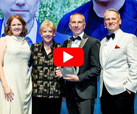 Four people on stage at the Travel Industry Awards with a trophy in hand