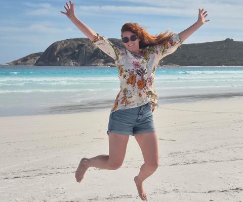 Gemma jumping on the sand on a beach in Western Australia 