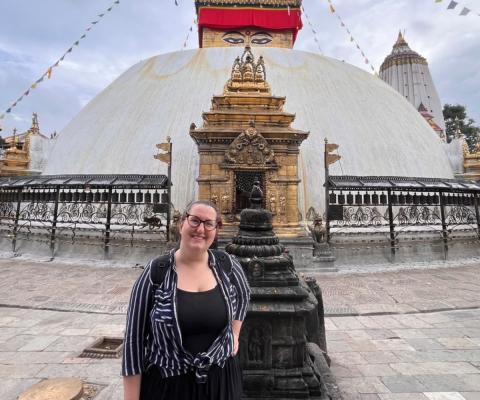 Woman smiling in front of temple in Nepal 