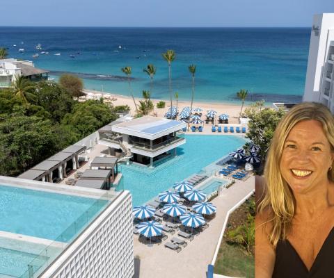 Woman smiling in front of picture of resort with pools 
