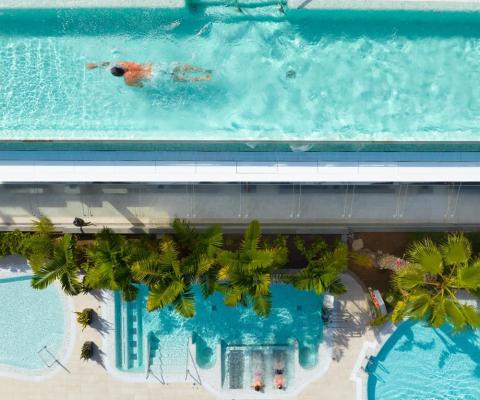Bird-eye view of a person swimming in a rooftop pool