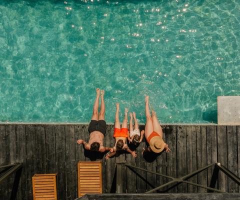A family relaxing by a pool on holiday