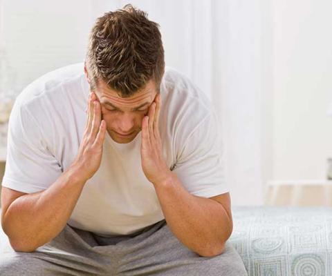 Sick man sitting on a bed