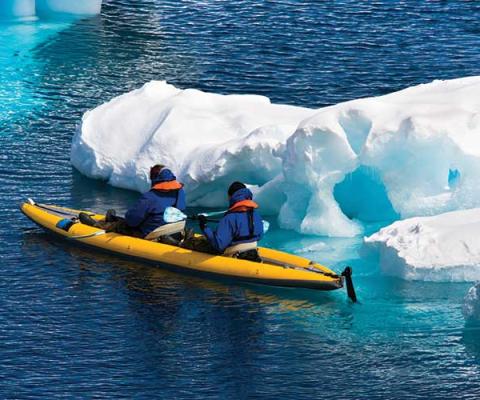 Two men in a canoe among ice floes