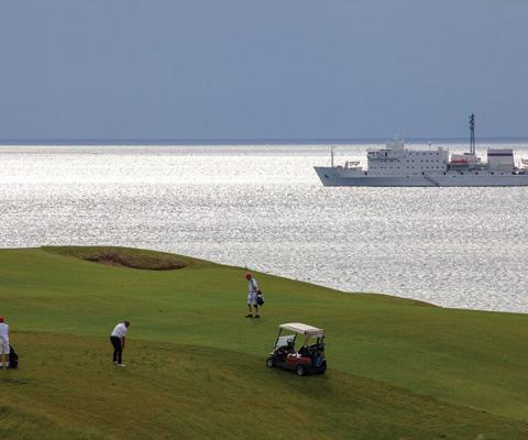 Playing golf on Cabot Links, Nova Scotia, with Akademik Ioffe in the background © Peter Ellegard-934