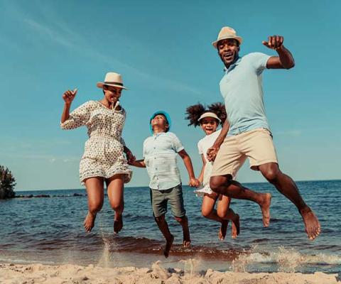 Family jumping in the surf on the beach