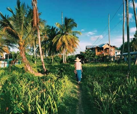 Guyana, lady walking through long grass
