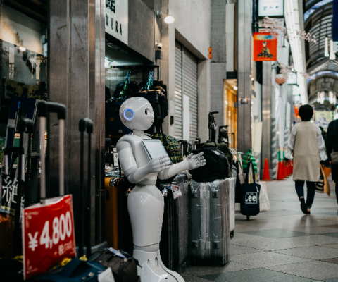 Robot standing by luggage_Photo by Lukas on Unsplash.png