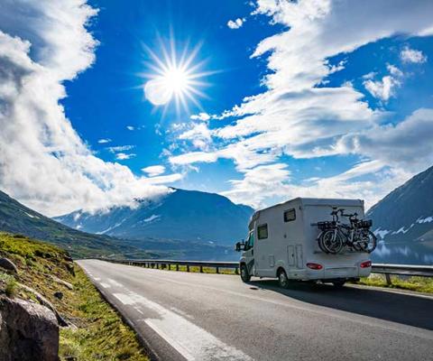Motorhome driving by fjord in European alps