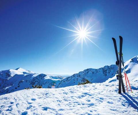 Skis stuck in the snow on a sunny piste