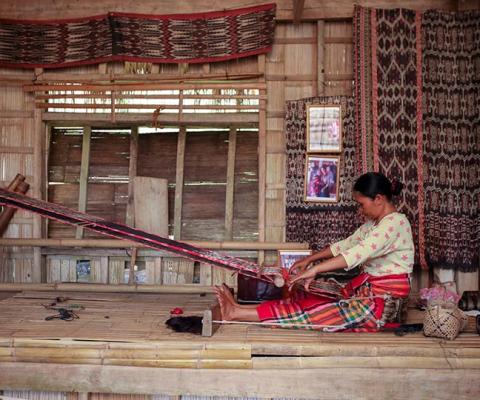 Filipina woman weaving on a loom
