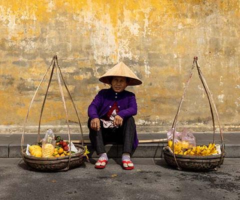 A fruit seller in the streets of Hoi An, where Just You’s Discover Vietnam itinerary visits community projects