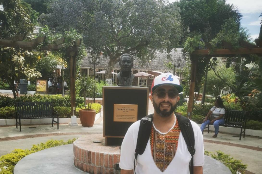 Man standing in front statue at Devon House in Jamaica