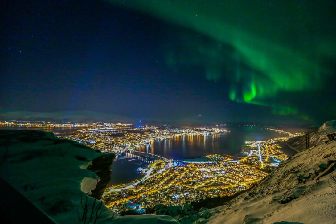 Hurtigruten Twinkling city lights with northern lights above