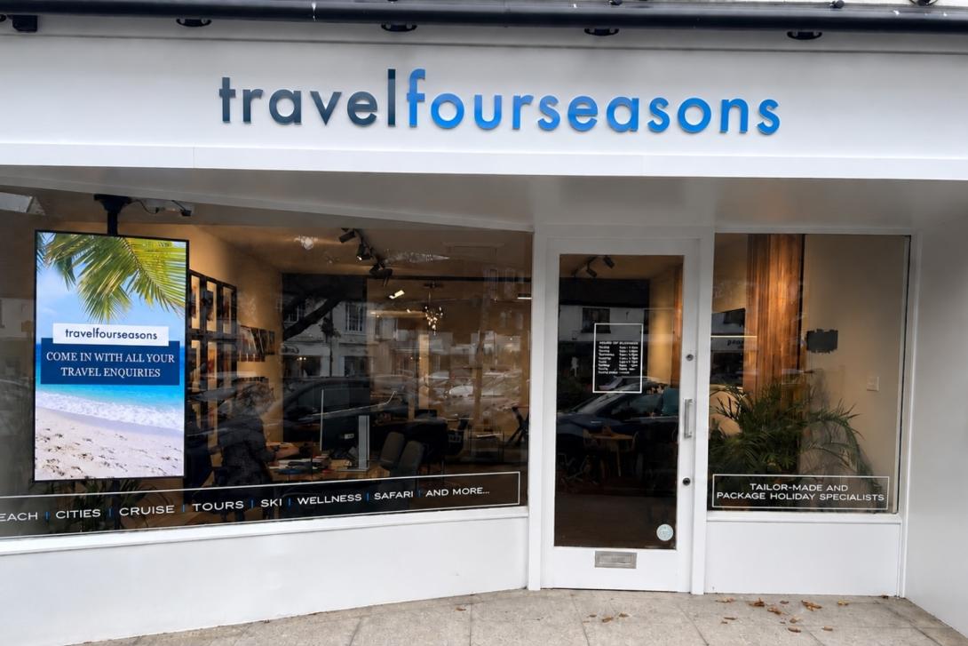 White shop front of travel agency called Travel Four Seasons