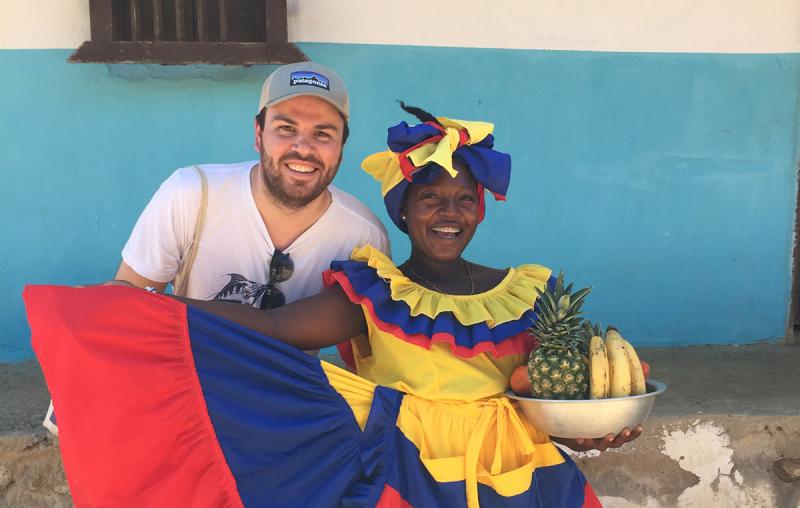 Charlie Thomas stands next to a Afro-Colombian woman wearing vibrant clothing