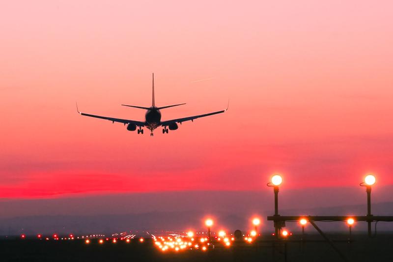 An aircraft coming in to land at sunset