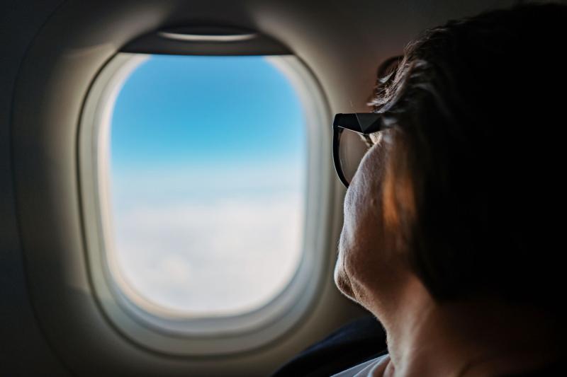 A passenger looks out the window of an aircraft