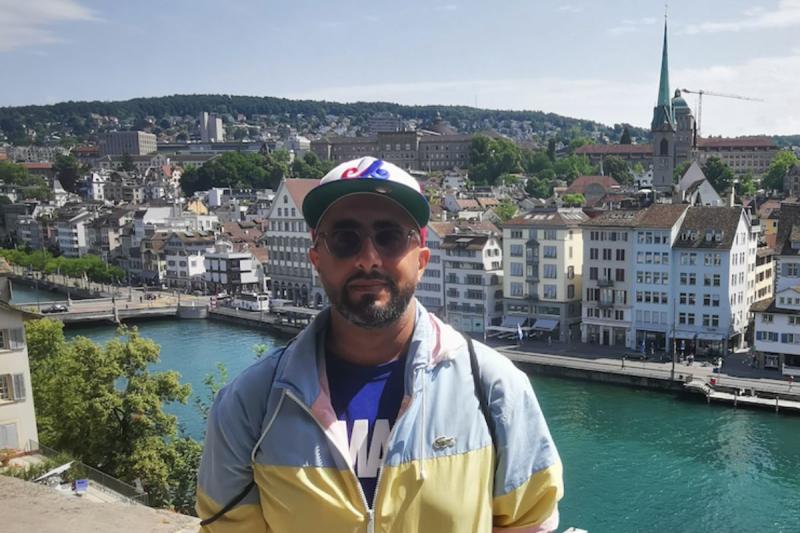 Man with sunglasses and hat in front of river in Europe