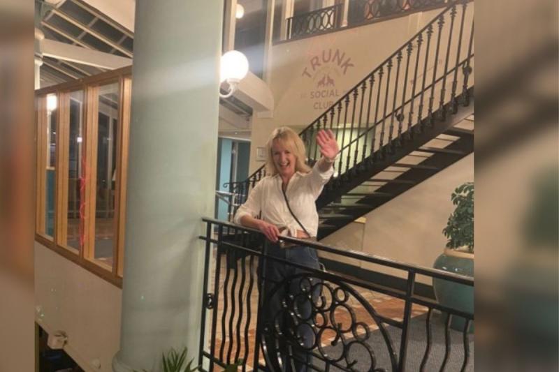 Woman with blonde hair smiling by balcony