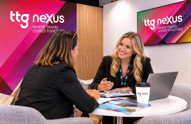 Two people talking at a stand with TTG Nexus branding in the background