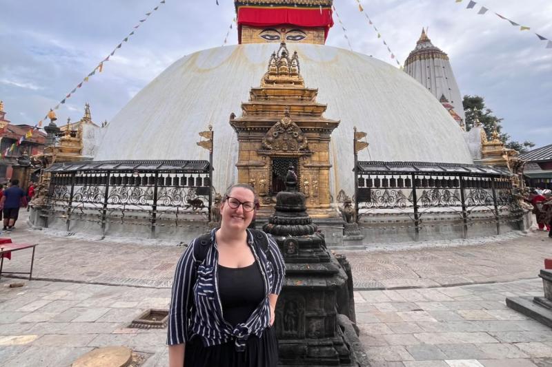 Woman smiling in front of temple in Nepal 