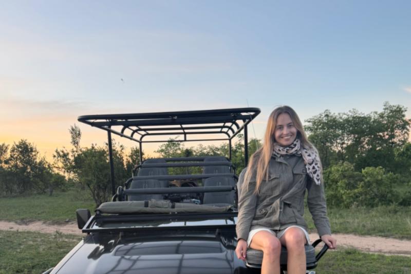 Woman sitting on jeep at safari 