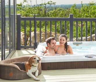 A dog and couple by a hot tub on a Hoseasons break