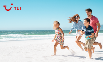 A family running on white sand beach